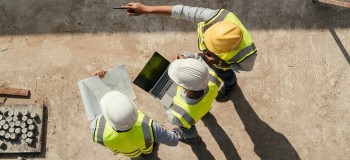 Team engineer building inspection use tablet computer and blueprint working at construction site