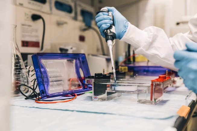 scientist in lab with pipette scaled