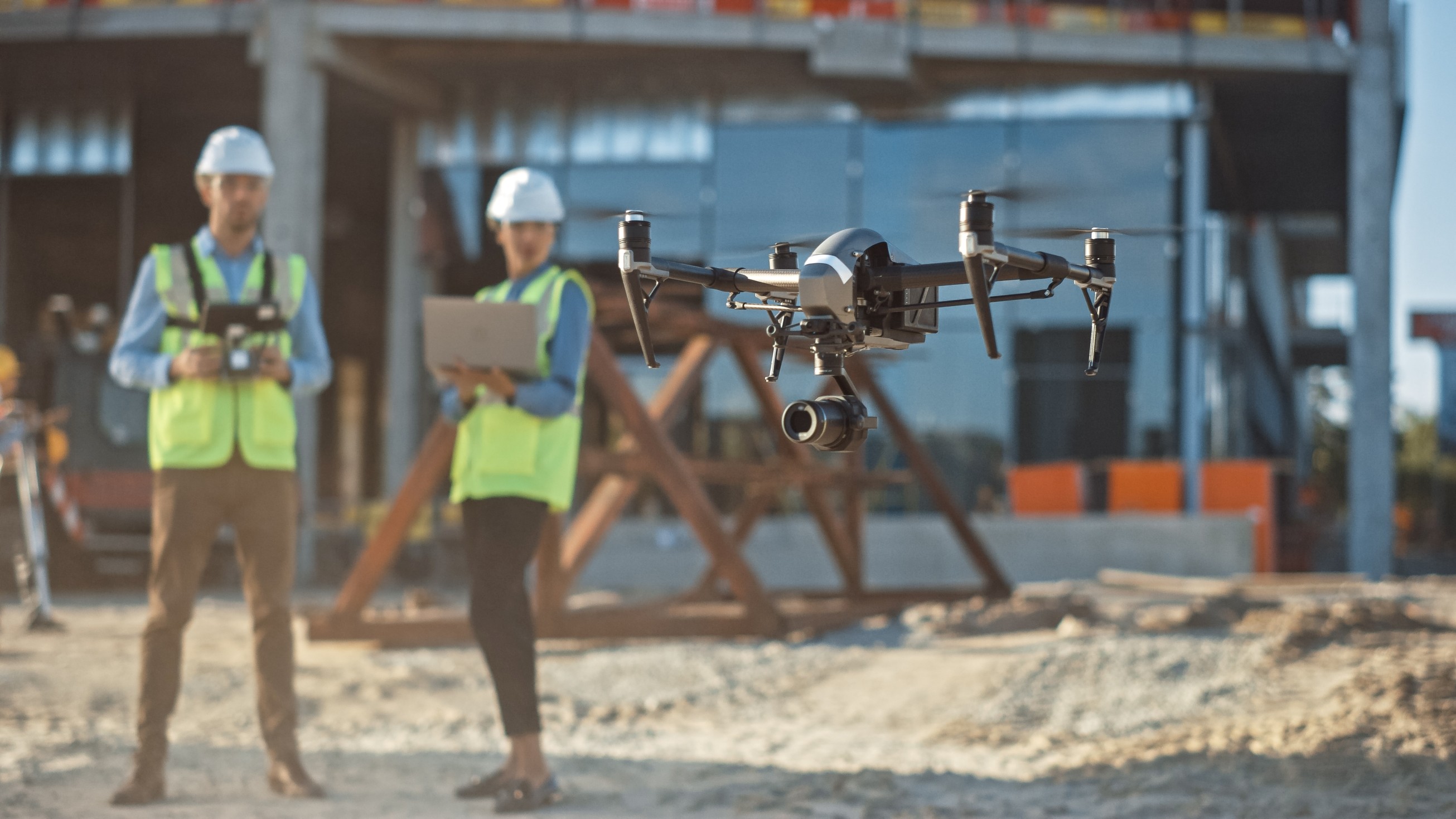 Diverse Team of Specialists Pilot Drone on Construction Site  Architectural Engineer and Safety Engineering Inspector Fly Drone on Commercial Building Construction Site Controlling Design